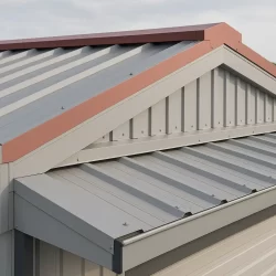 Cubierta industrial con panel sándwich gris y remates metálicos instalados en cumbrera, laterales y canalón.